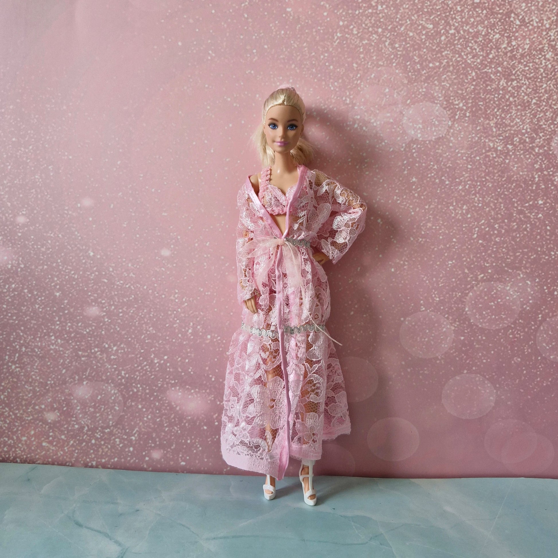 Blonde Barbie doll wearing delicate pink lace robe and lingerie, one of three included sets.