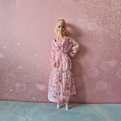 Blonde Barbie doll wearing delicate pink lace robe and lingerie, one of three included sets.