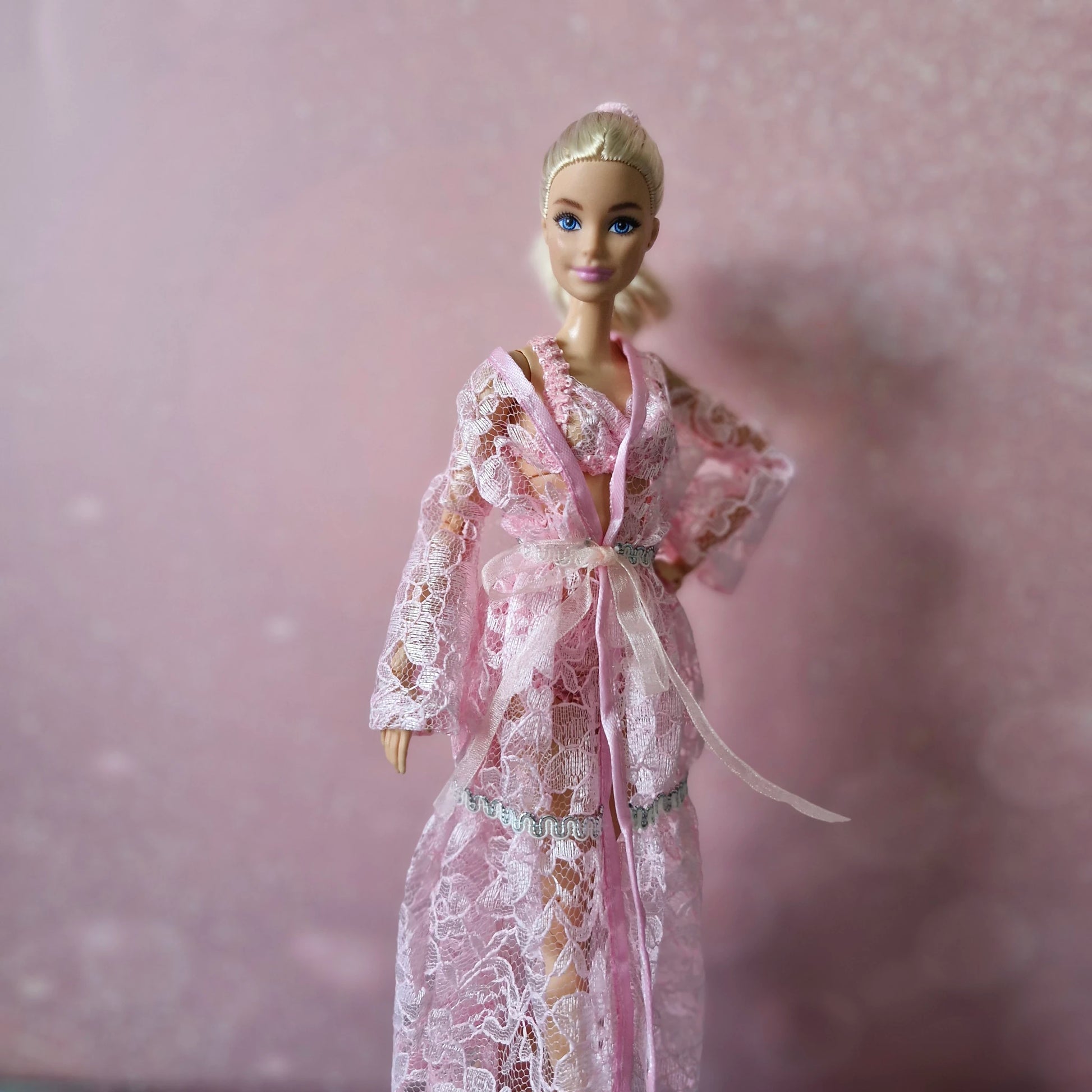 Blonde Barbie doll in pink lace robe with satin tie, from luxurious 3-piece lingerie set.