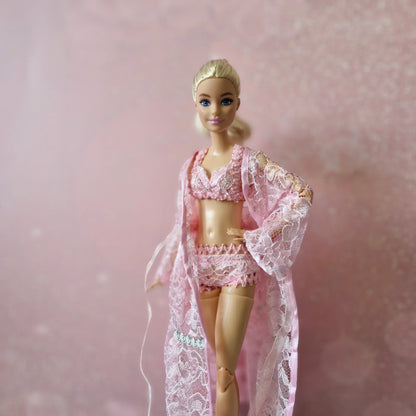 Blonde Barbie doll models elegant pink lace robe and lingerie, part of 3-set collection.