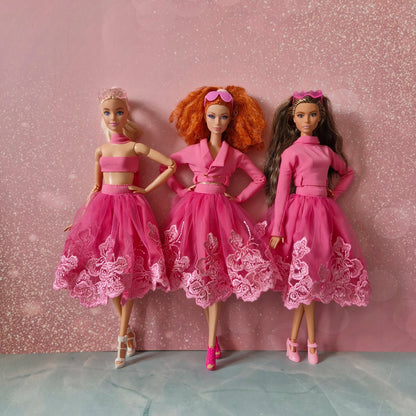 Three Barbie dolls showcasing versatile pink lace skirt outfit: bandeau, jacket, mock neck.