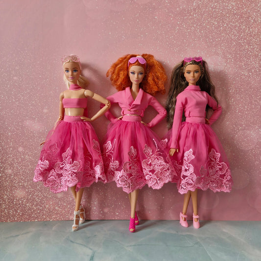 Three Barbie dolls showcasing versatile pink lace skirt outfit: bandeau, jacket, mock neck.