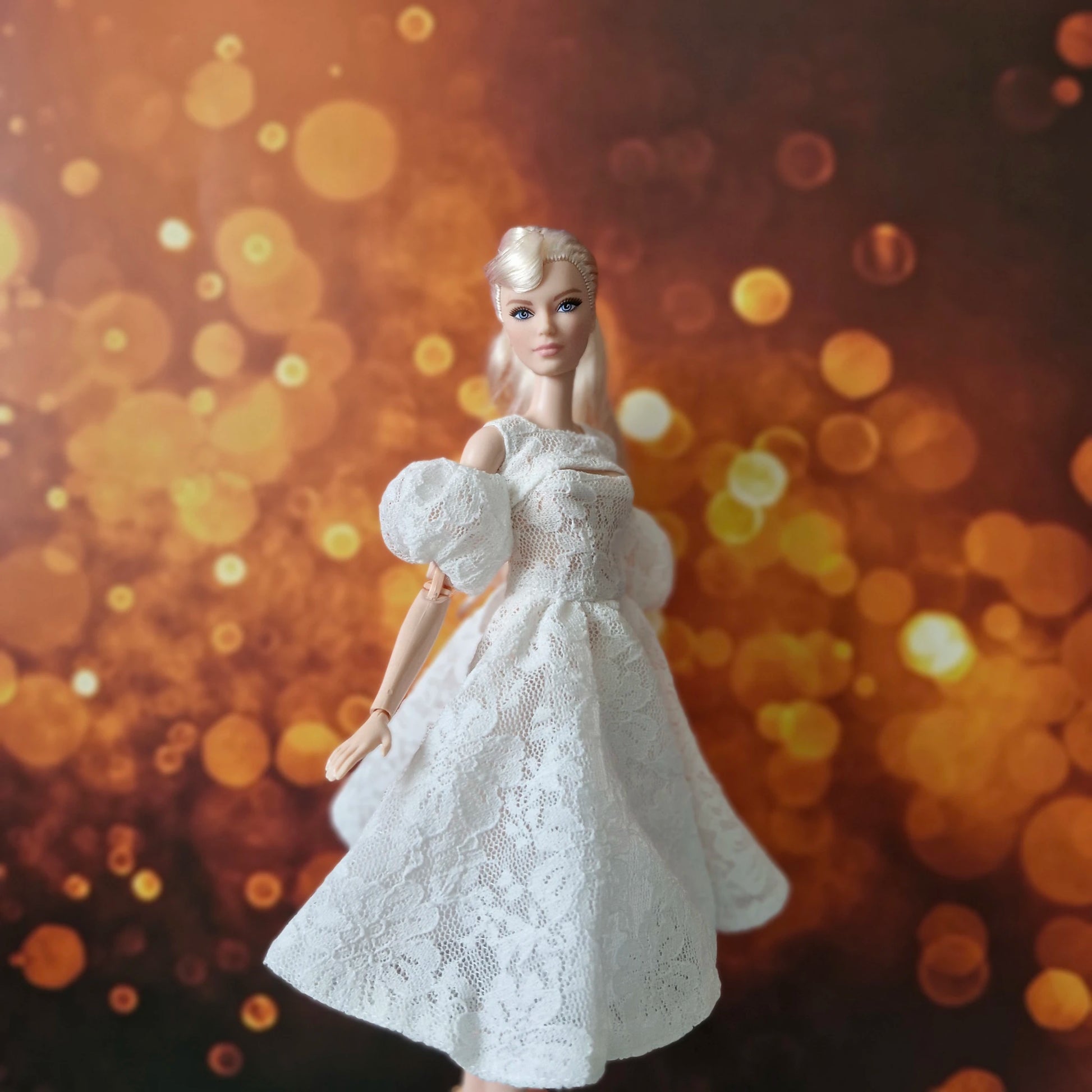 Blonde Barbie doll in elegant white lace dress with puff sleeves, gentle movement.