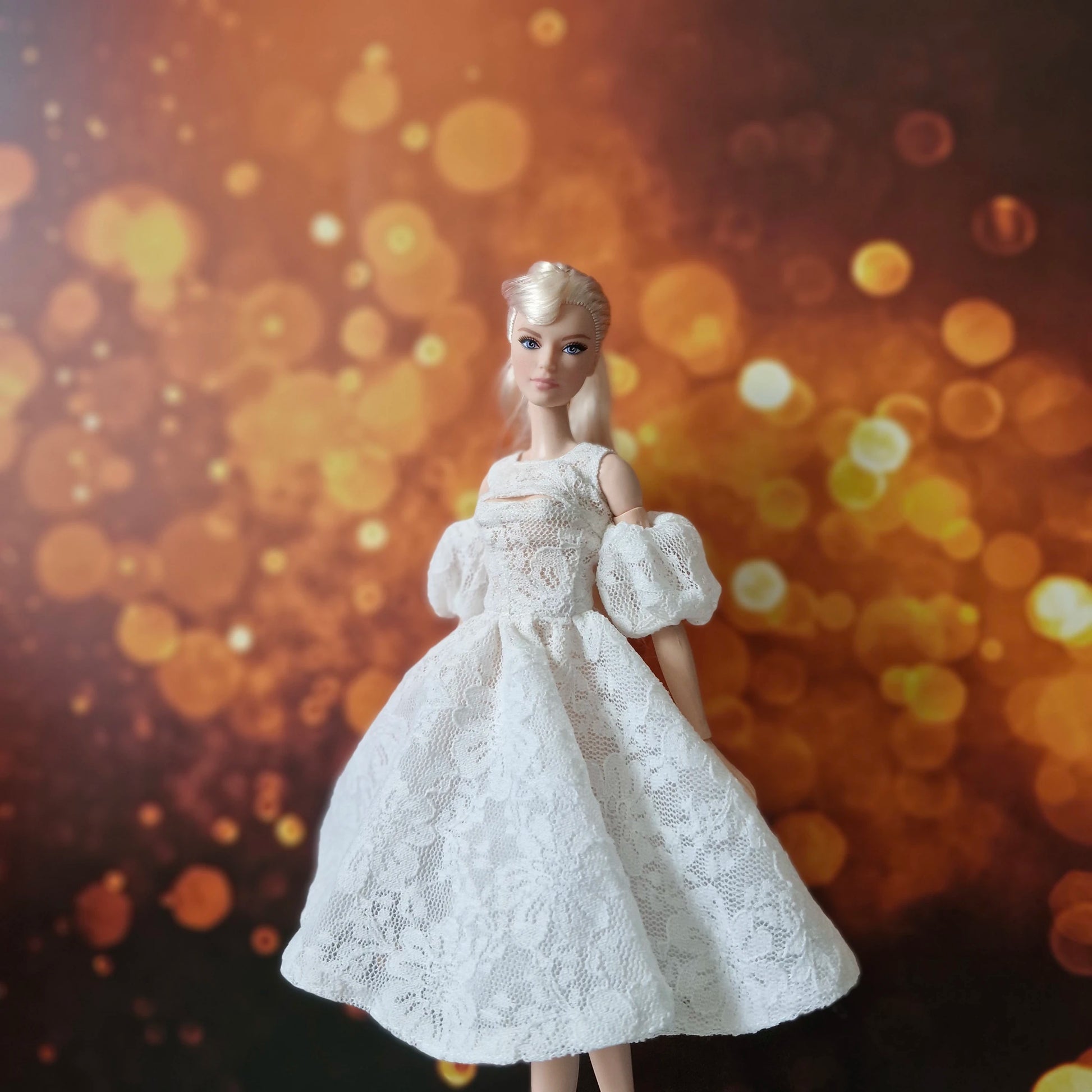 Blonde Barbie in sophisticated white lace A-line dress with puff sleeves, warm bokeh.