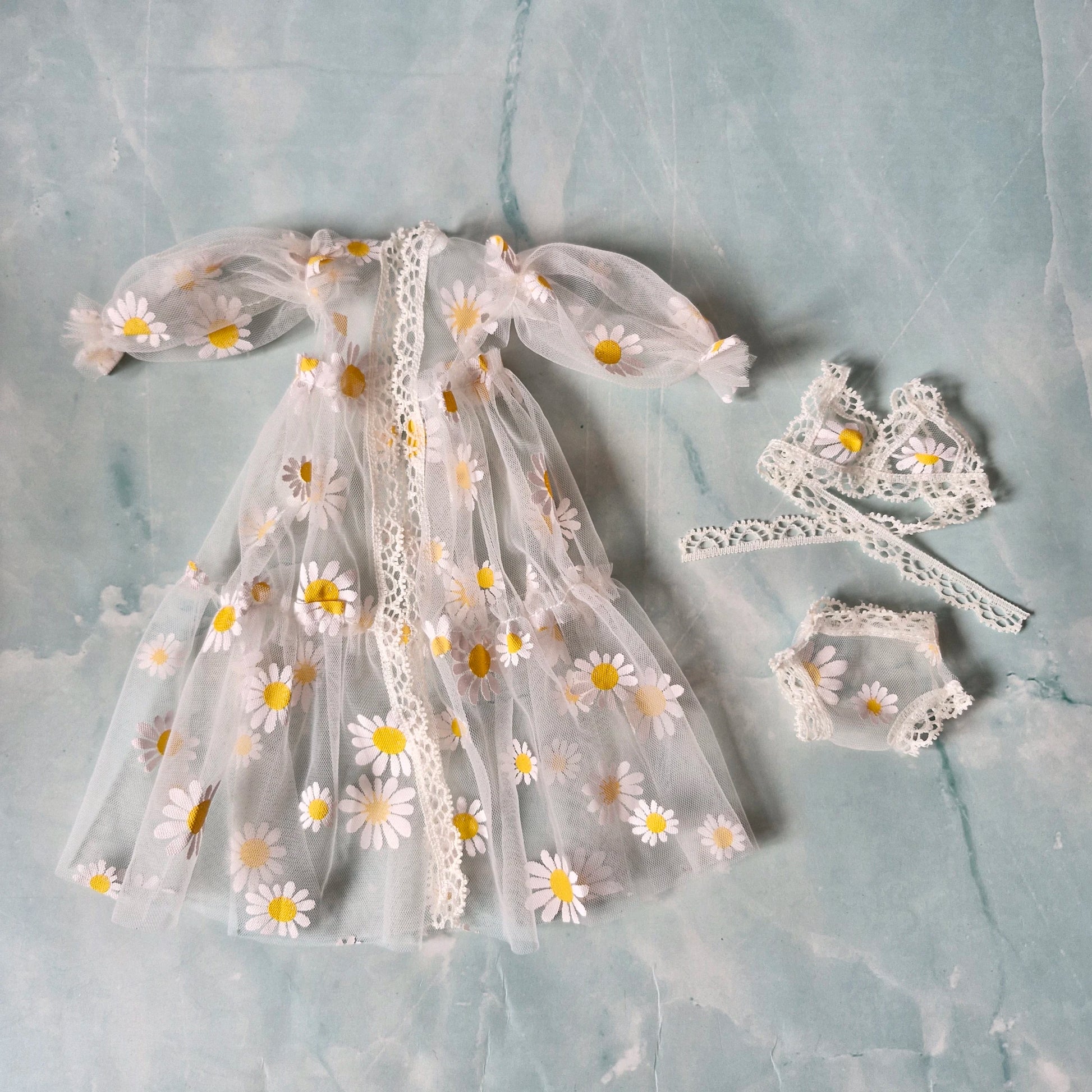 Flat lay of white sheer daisy print Barbie doll robe and lingerie set from collection.