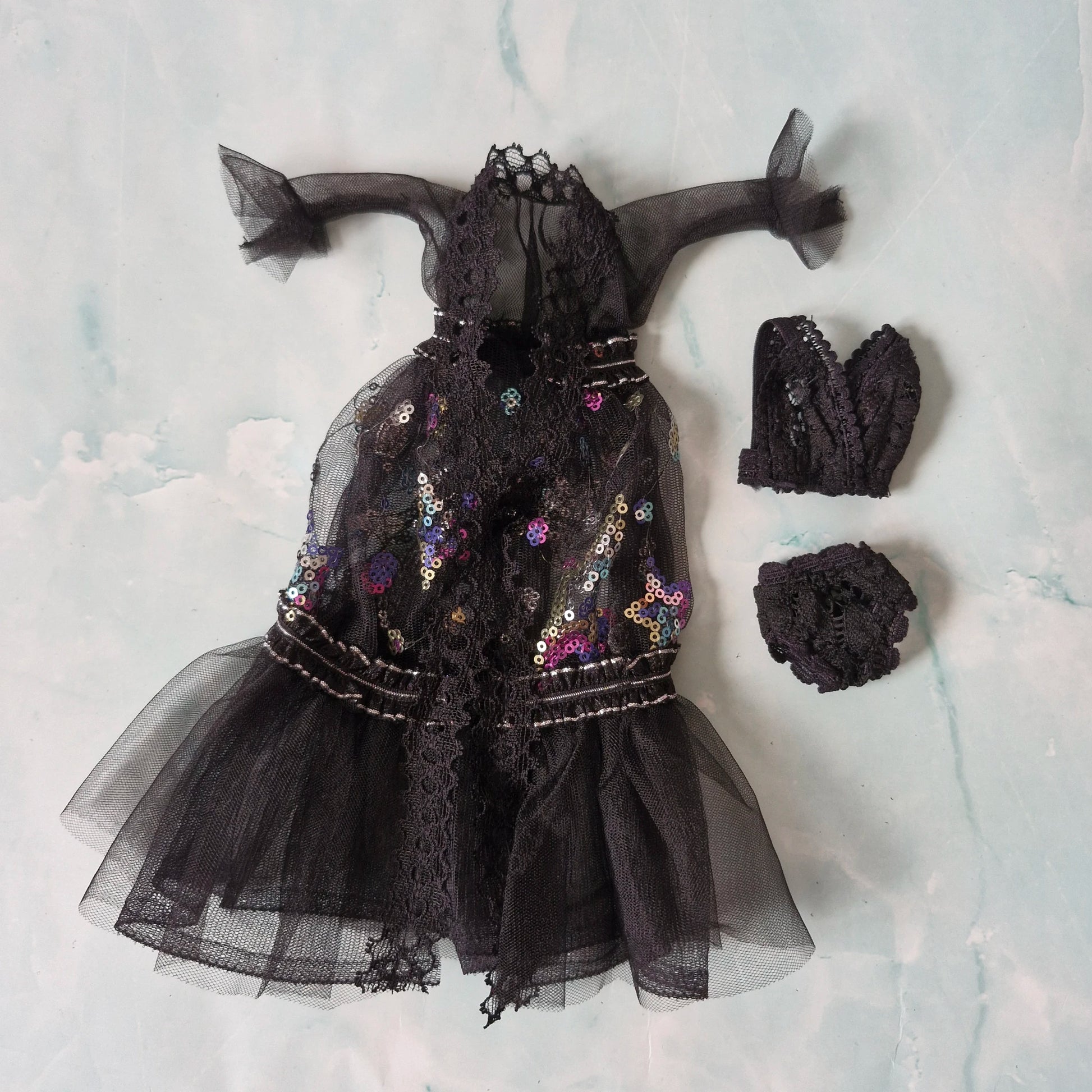Flat lay of black sheer Barbie doll robe with sequins and lingerie, included in 3-set.