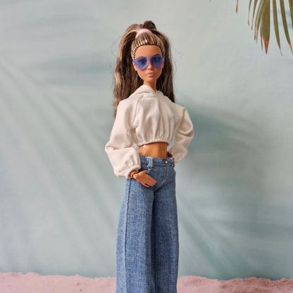 Barbie doll in white cropped hoodie and dark wash wide-leg denim jeans, blue sunglasses.