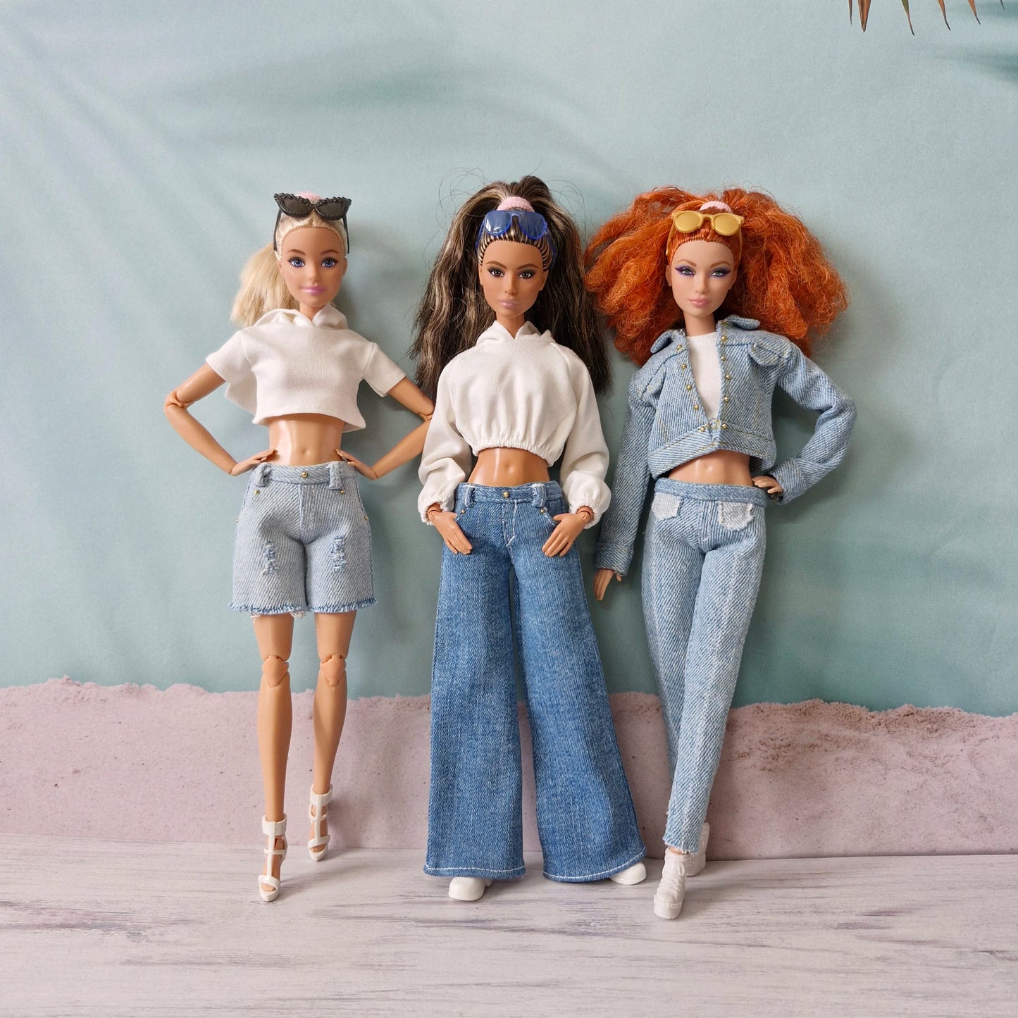 Three Barbie dolls showcasing denim street style outfits: shorts, wide-leg jeans, and full denim set.
