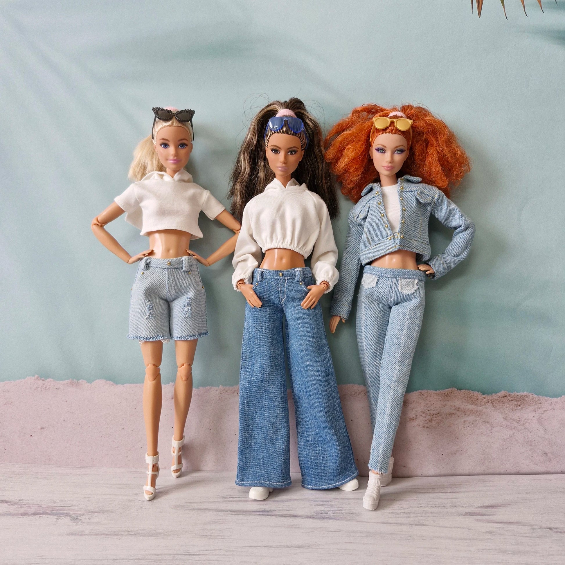 Three Barbie dolls showcasing denim street style outfits: shorts, wide-leg jeans, and full denim set.