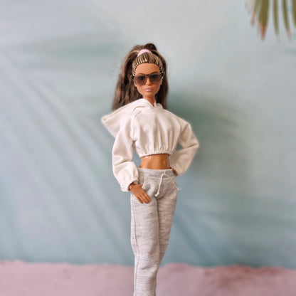 Stylish Barbie doll in white hoodie, grey sweatpants, and sunglasses - athleisure look.