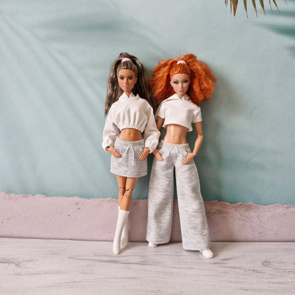 Two Barbie dolls in mix-and-match white and grey athleisure outfits - skirt and wide pants.