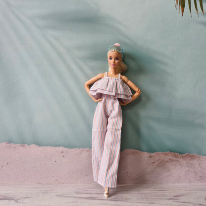 Barbie doll posing confidently in pastel striped ruffle jumpsuit, hands on hips.
