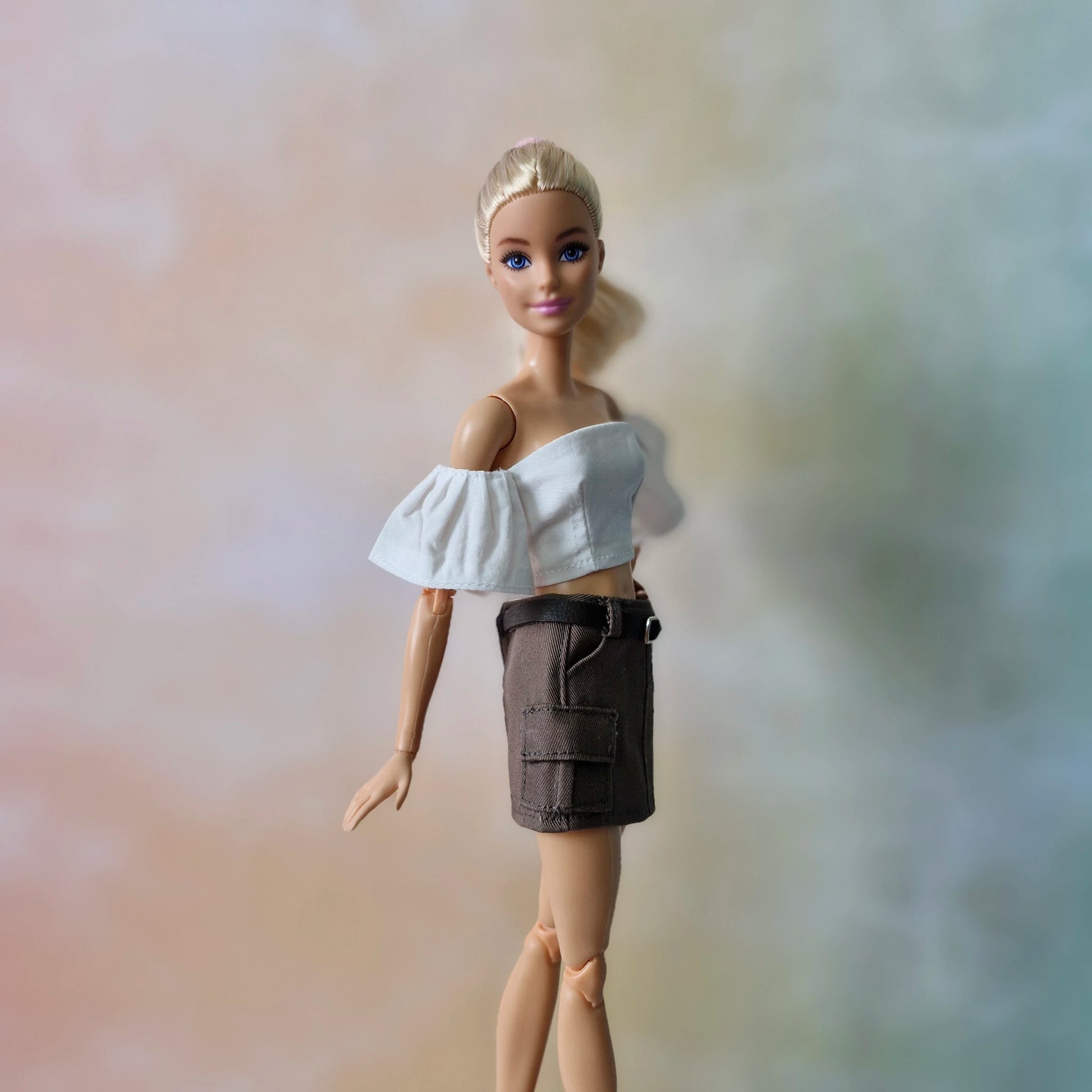 Barbie doll in chic white off-shoulder crop top and brown cargo skirt, casual style.