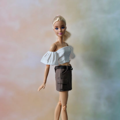 Barbie doll in chic white off-shoulder crop top and brown cargo skirt, casual style.