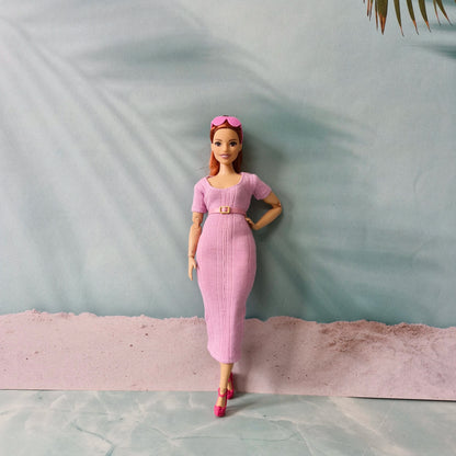 Barbie doll in pink ribbed midi dress styled with a matching pink belt and pink heels.