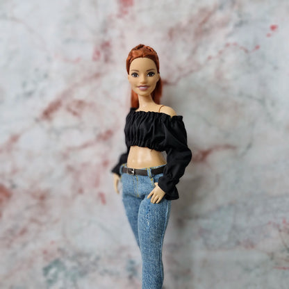 Side view of Curvy Barbie doll wearing black off-shoulder crop top and skinny jeans.