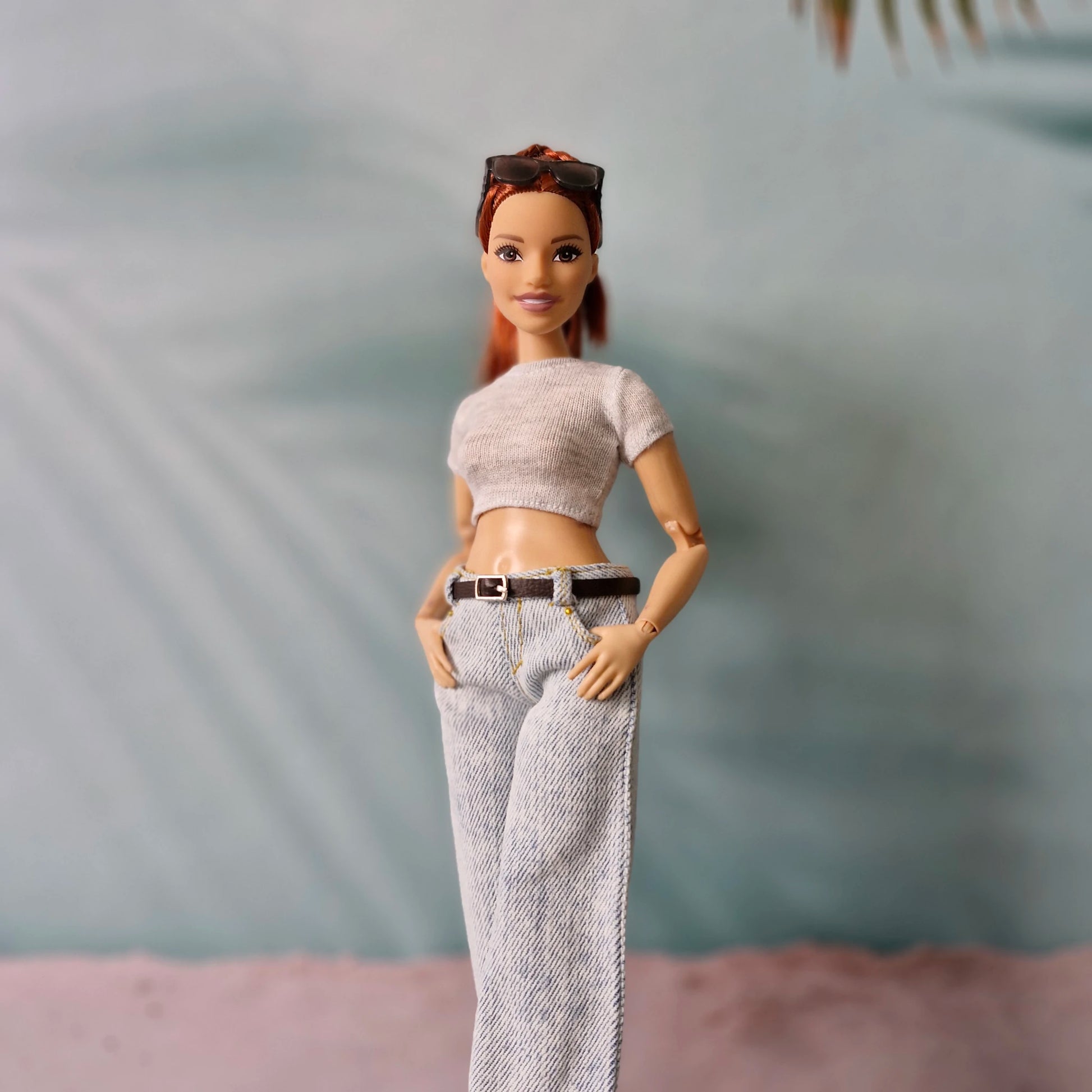 Barbie doll wearing a crop top and jeans with a blurred background
