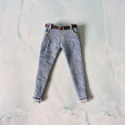 Pair of blue jeans with a brown belt on a light gray marble surface