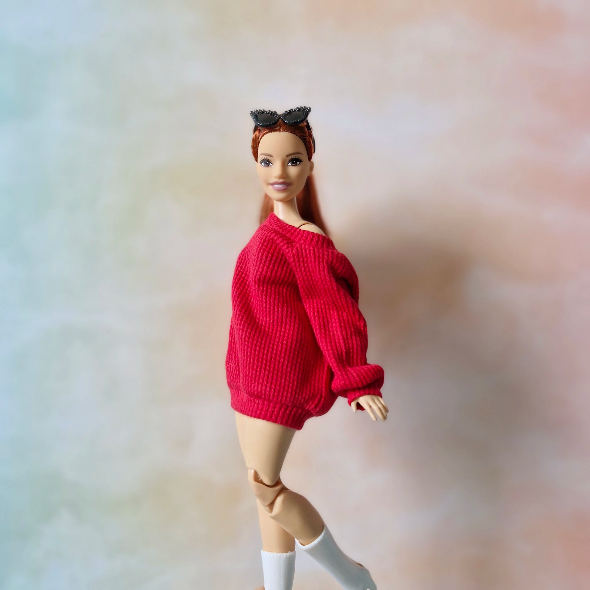 Barbie doll wearing a red sweater on a blurred background