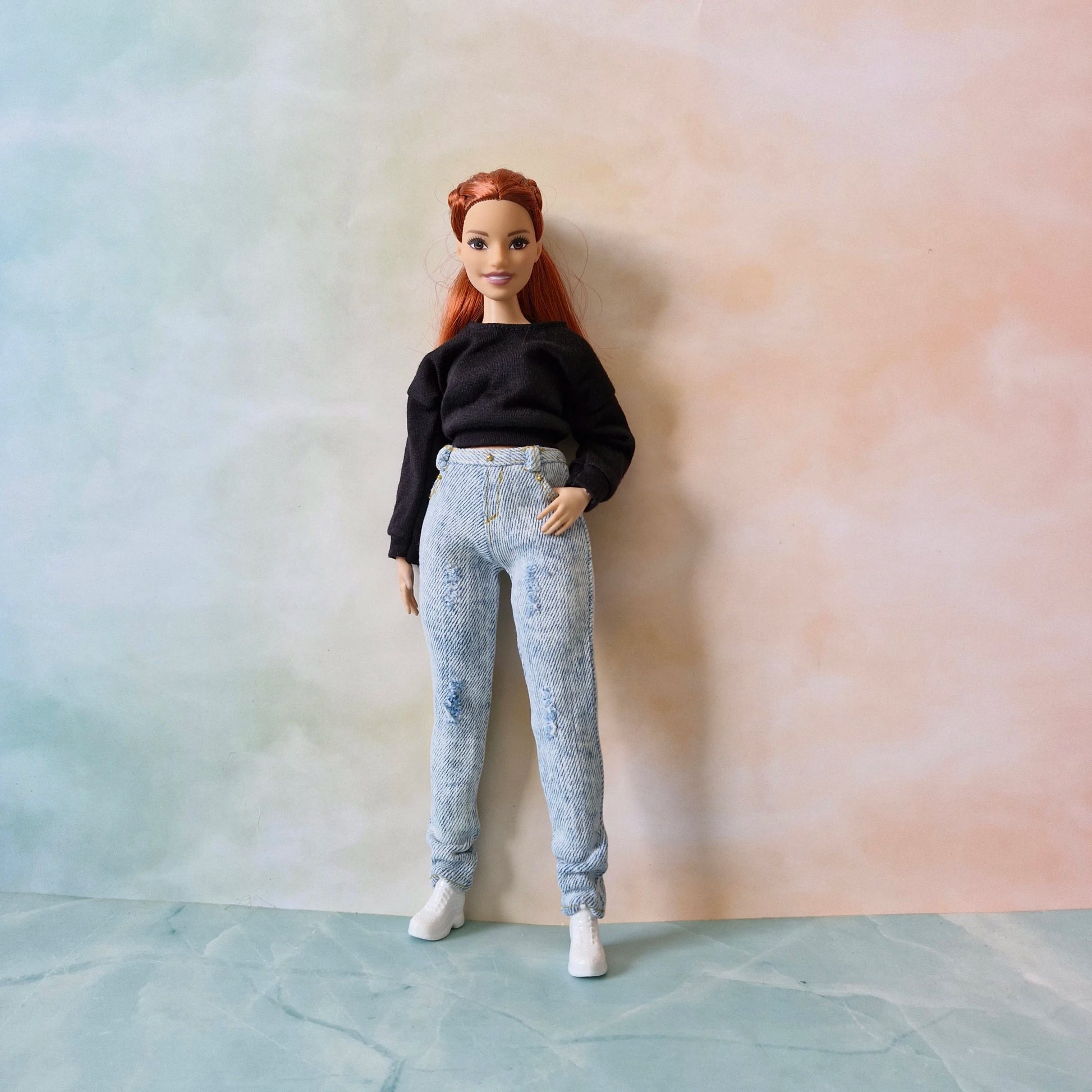 Curvy Barbie doll in black long sleeve shirt and distressed white jeans
