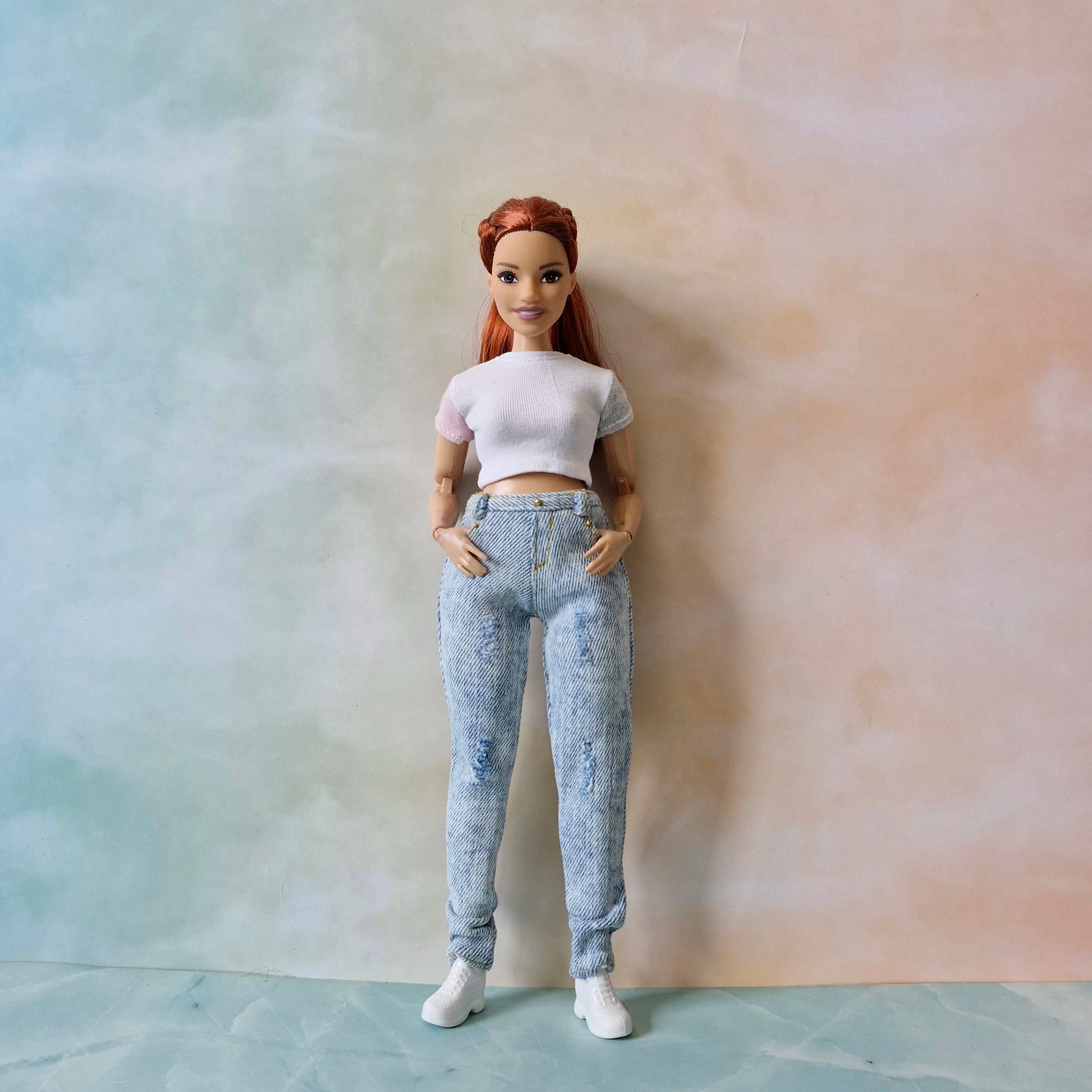 Curvy Barbie doll modeling a white short sleeve shirt and acid wash jeans
