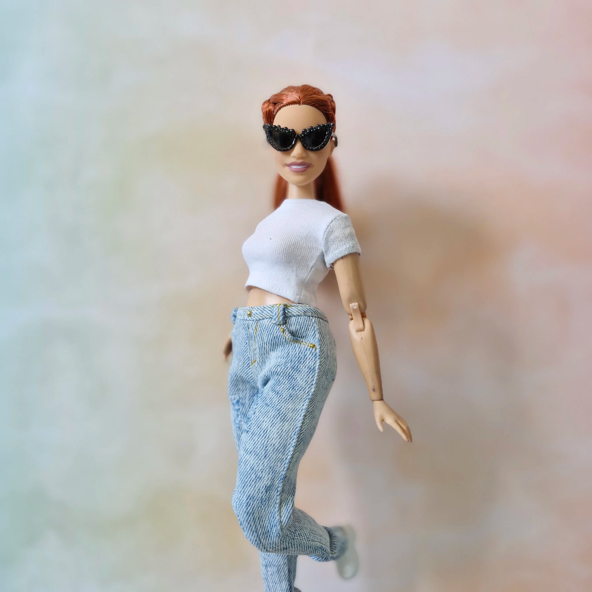 Curvy Barbie doll in white top and jeans with black studded sunglasses
