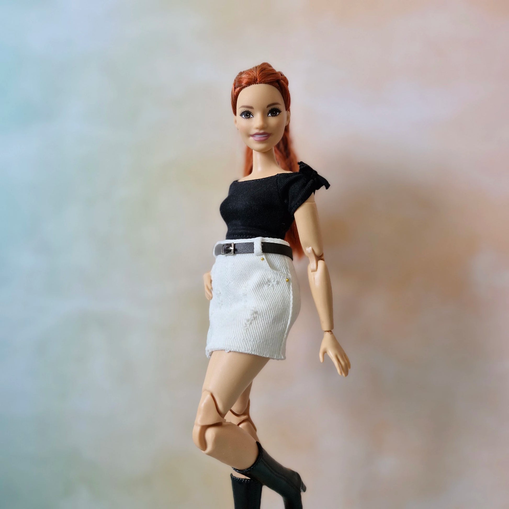 Curvy Barbie wearing black crop top and white mini skirt with black boots