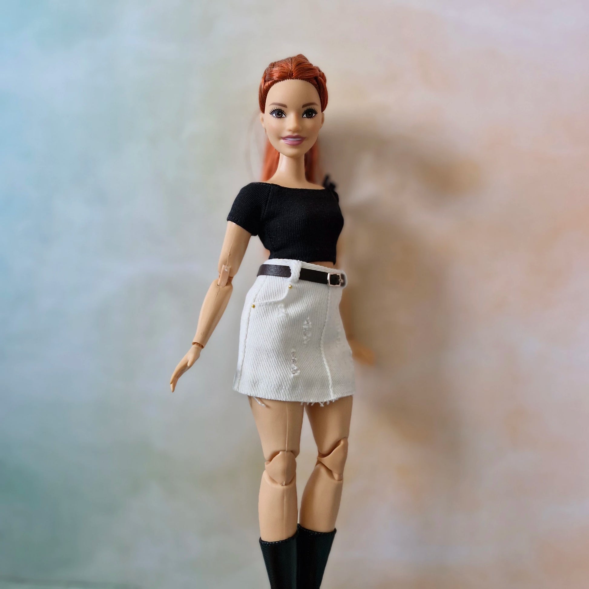 Curvy Barbie doll with white mini skirt and black crop top side view