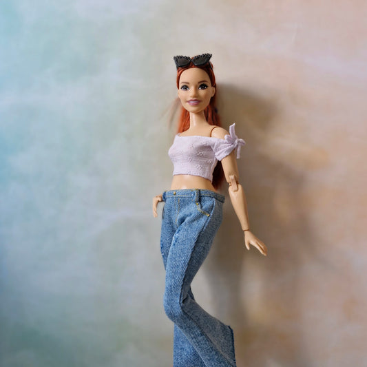Curvy Barbie wearing white crop top and flared blue jeans with cat-eye sunglasses
