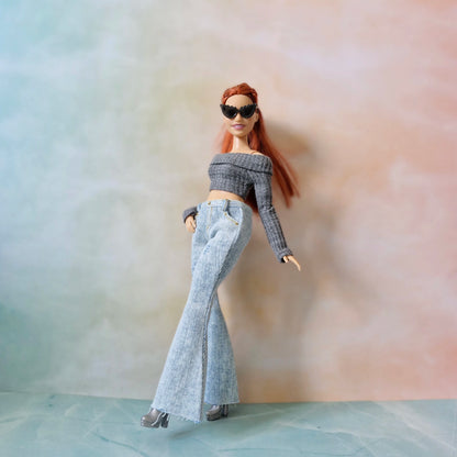 Barbie curvy doll posing in gray top, flared jeans, and black sunglasses