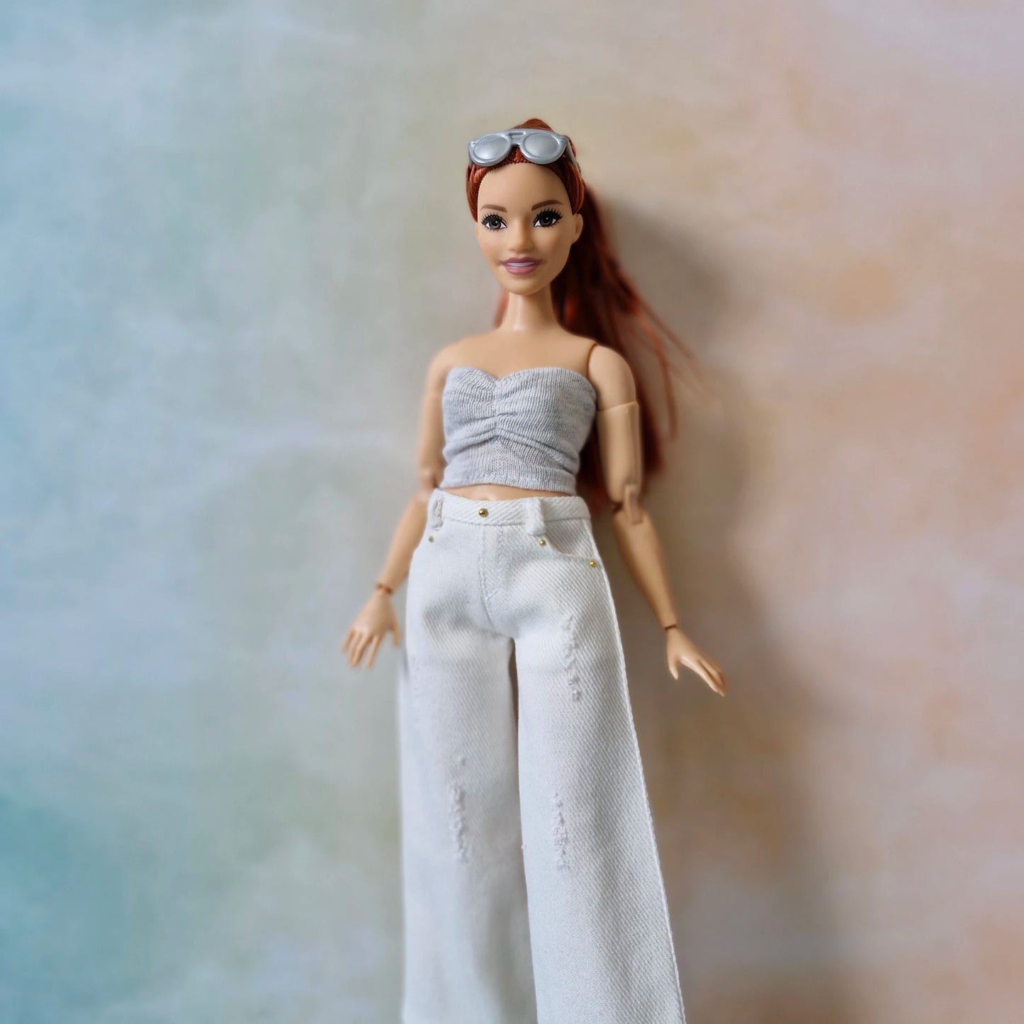 Barbie wearing ruched strapless top and high-waisted white jeans with silver sunglasses