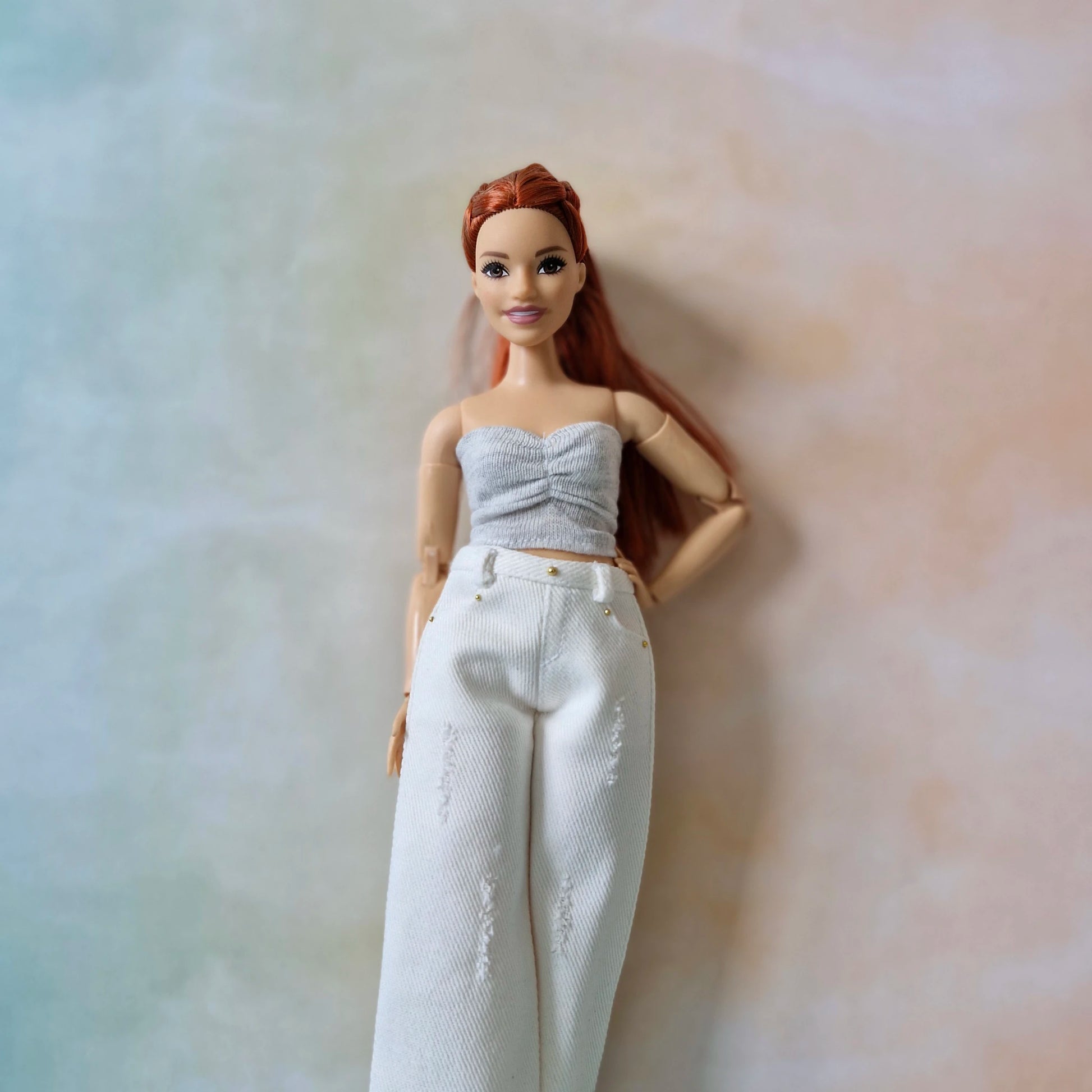 Curvy Barbie close-up in white jeans and ruched gray crop top