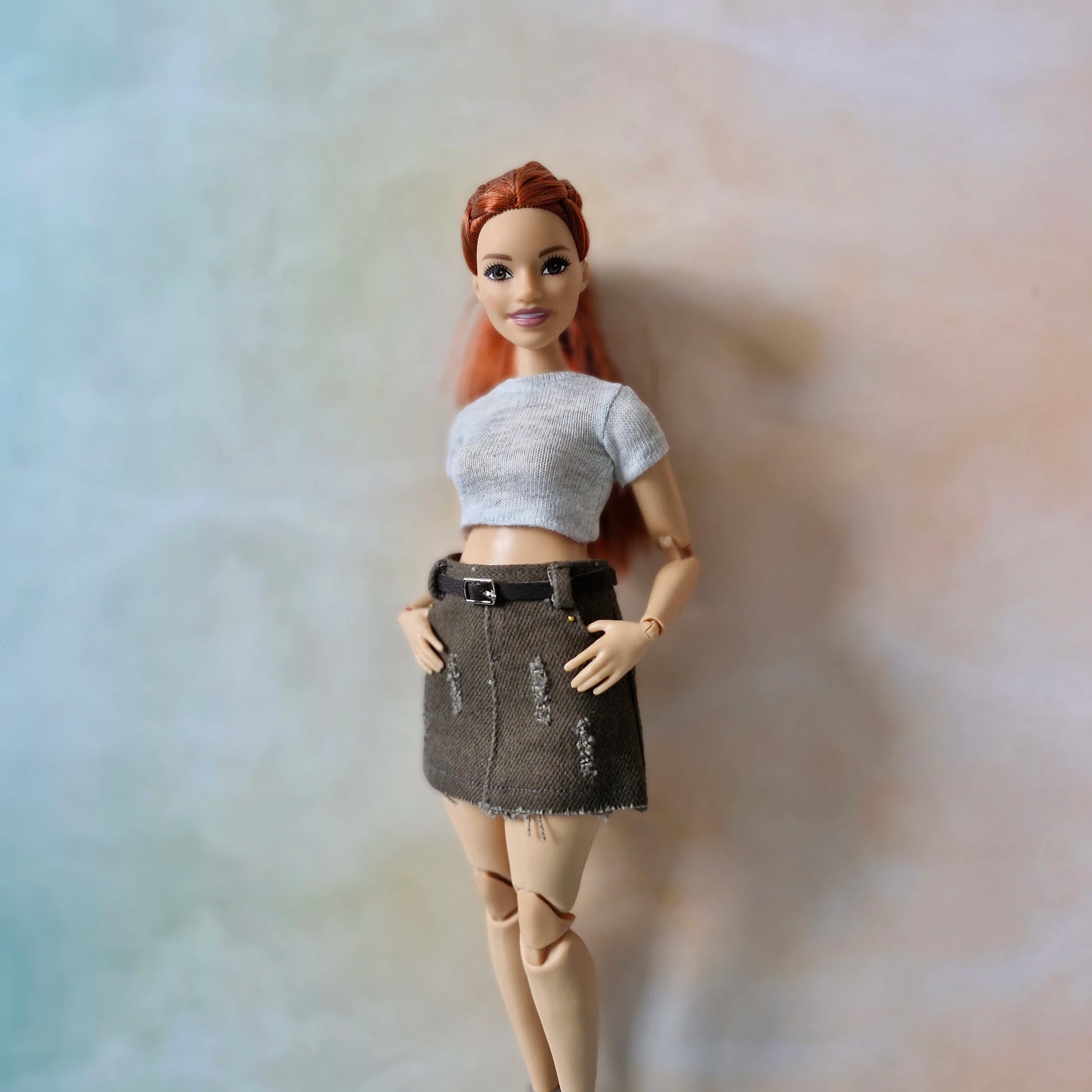 Barbie wearing gray crop top and brown distressed mini skirt