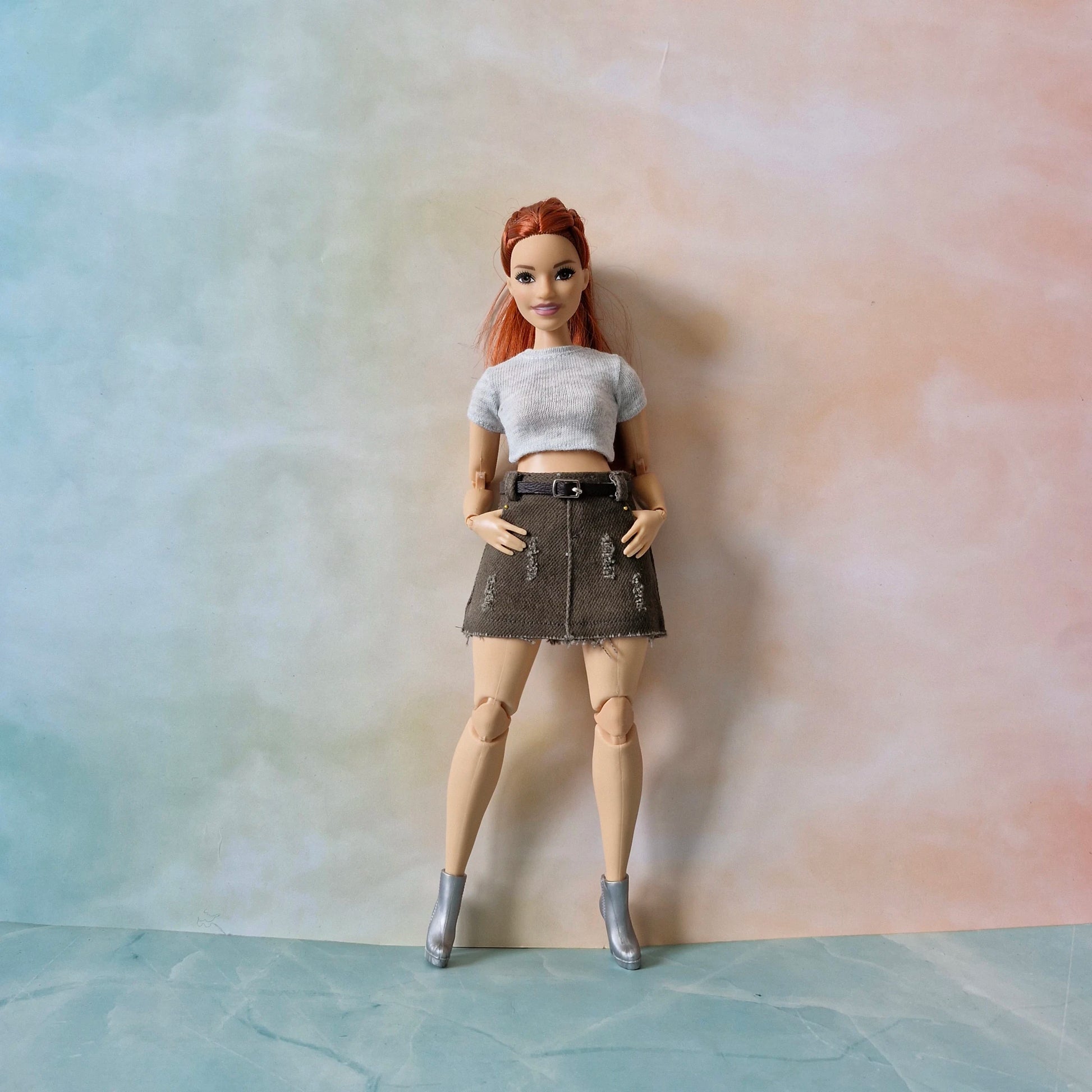 Full body of Curvy Barbie in light gray top and brown mini skirt