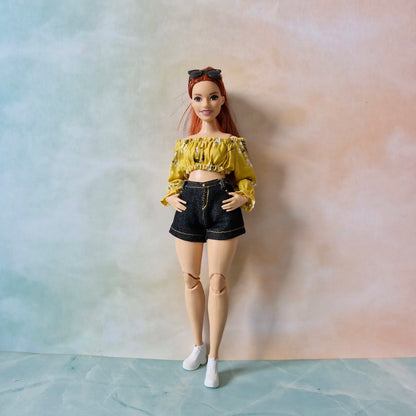 Curvy Barbie doll wearing the 'Summer Sunshine' outfit with a yellow floral top and black denim shorts.