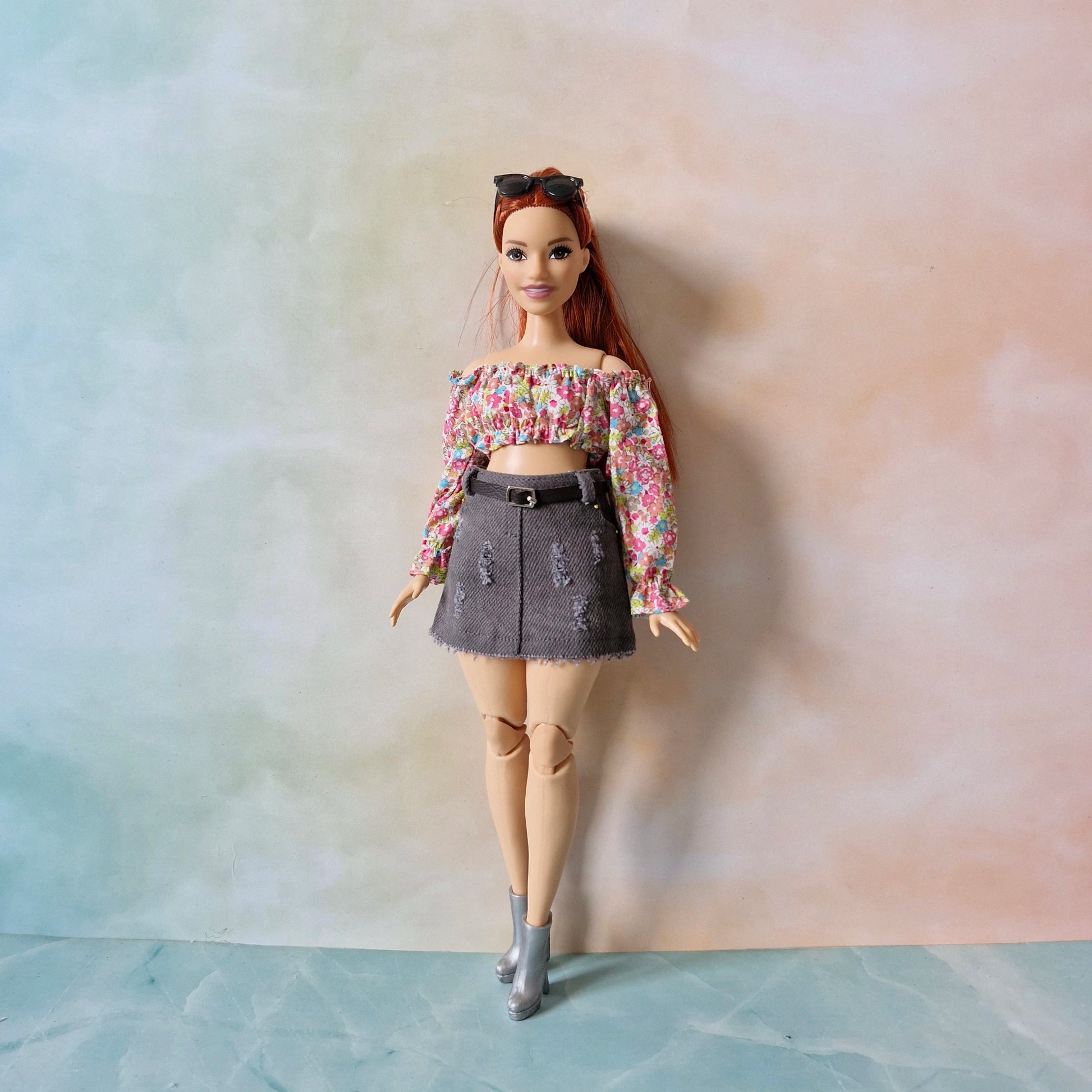 Curvy Barbie doll wearing the 'City Chic' outfit with a floral long-sleeve top and grey denim skirt.