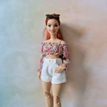 Curvy Barbie doll modeling a handmade multi-color floral top with white shorts.
