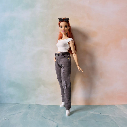 Curvy  Barbie doll with red hair and a white top against a gradient wall