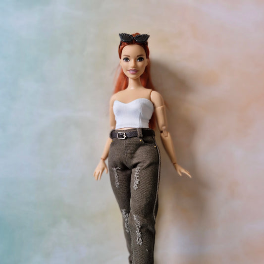 Curvy Curvy Barbie doll with red hair and white top on a neutral background