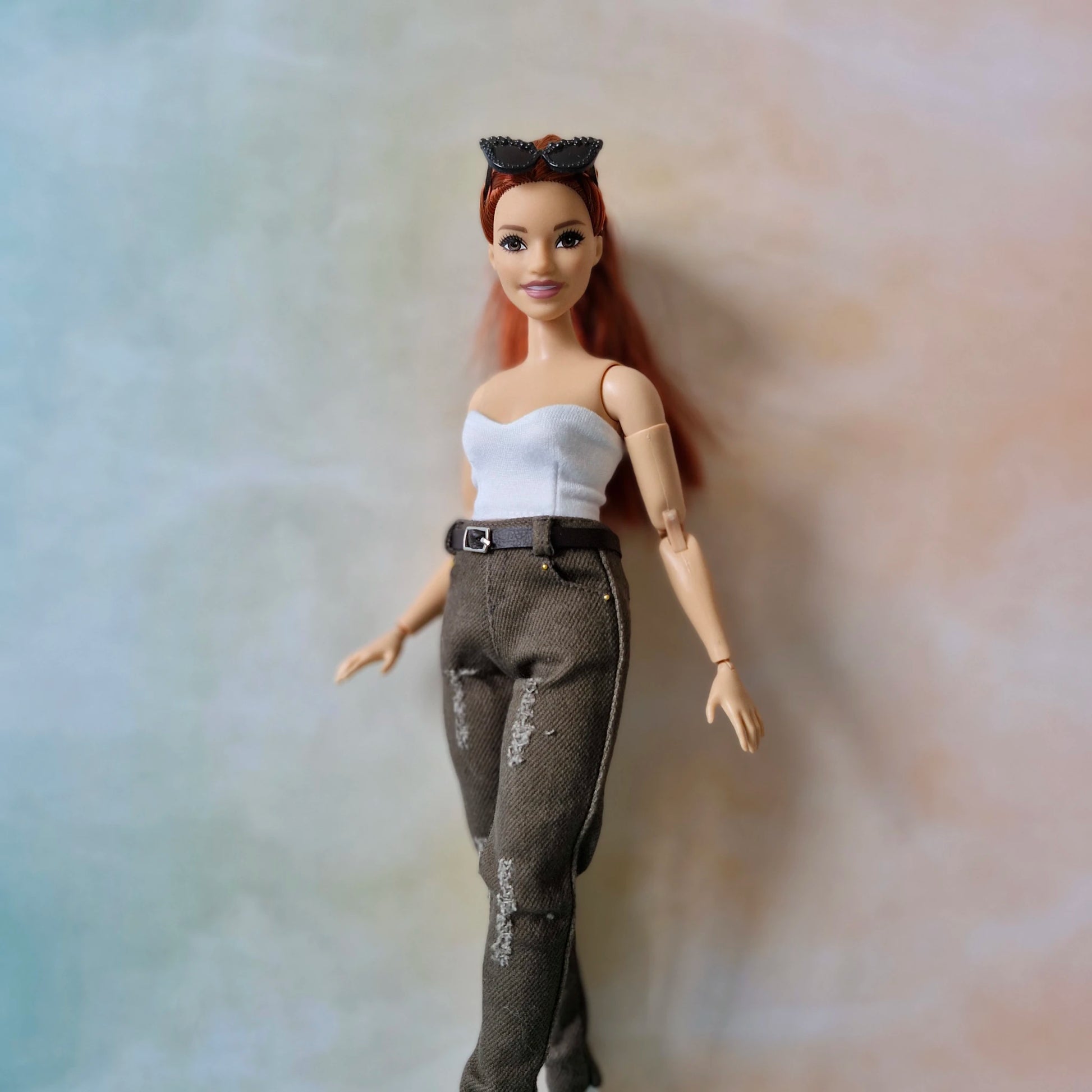 Curvy  doll with red hair and a white top on a neutral background