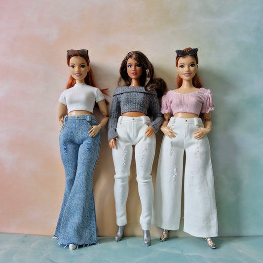 Three dolls wearing different outfits against a gradient background