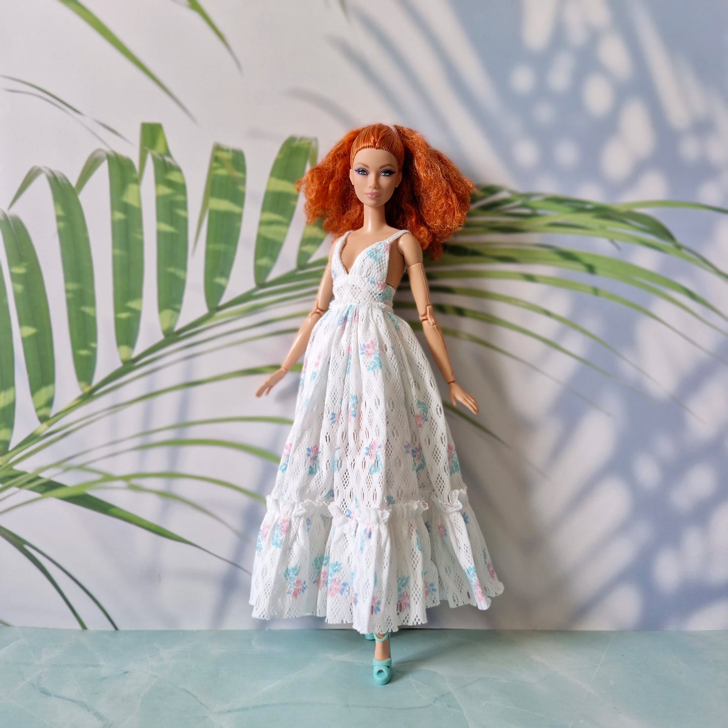 Barbie doll wearing white lace floral maxi dress with deep V neck and ruffles