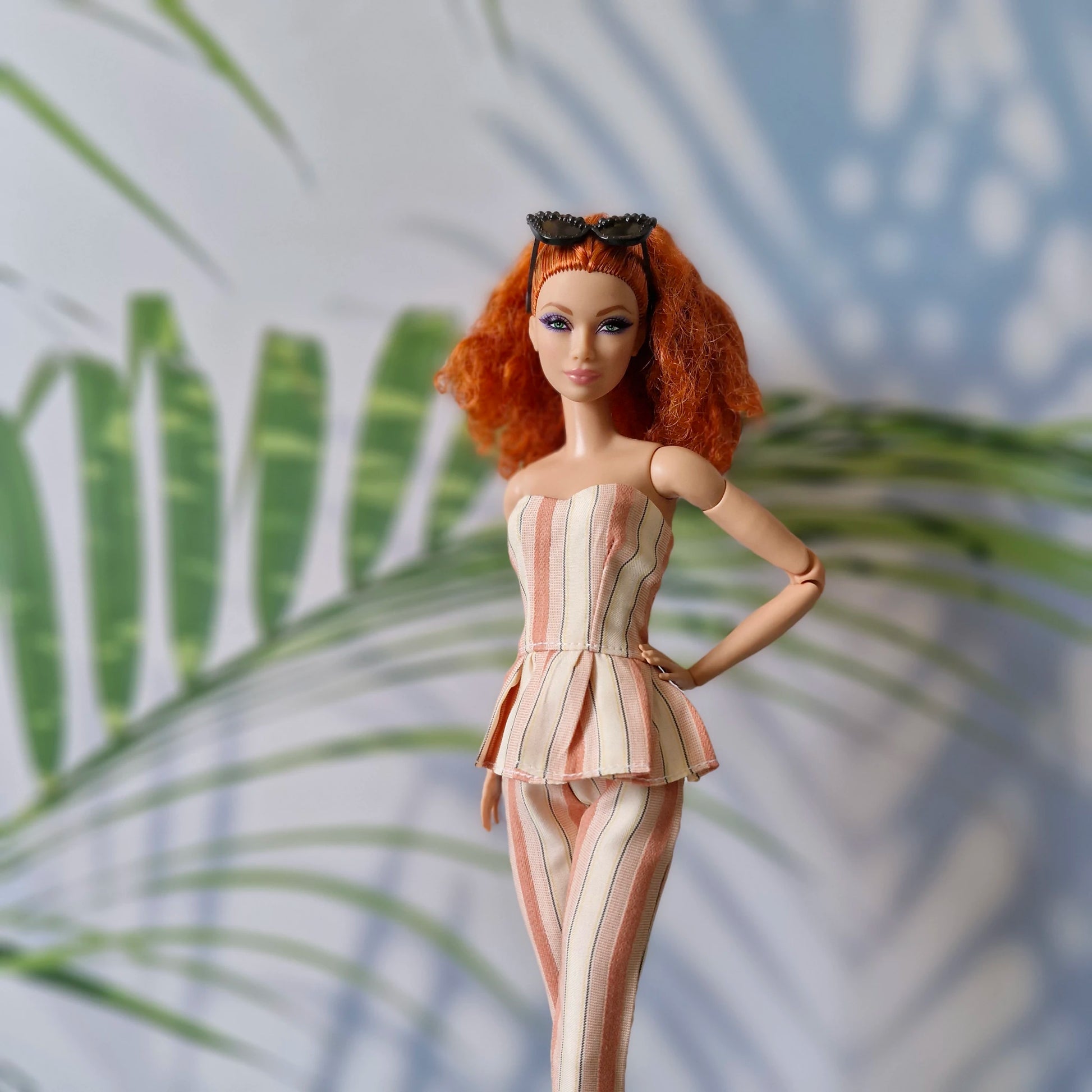 Barbie doll in a striped outfit with a leafy background