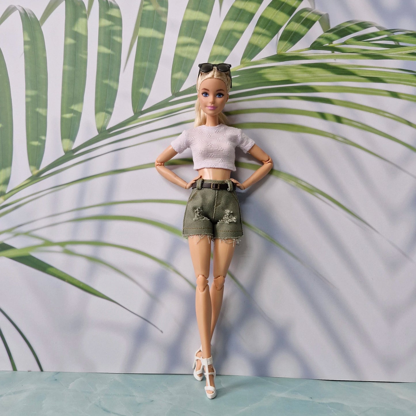Barbie doll in a stylish outfit with a tropical leaf background