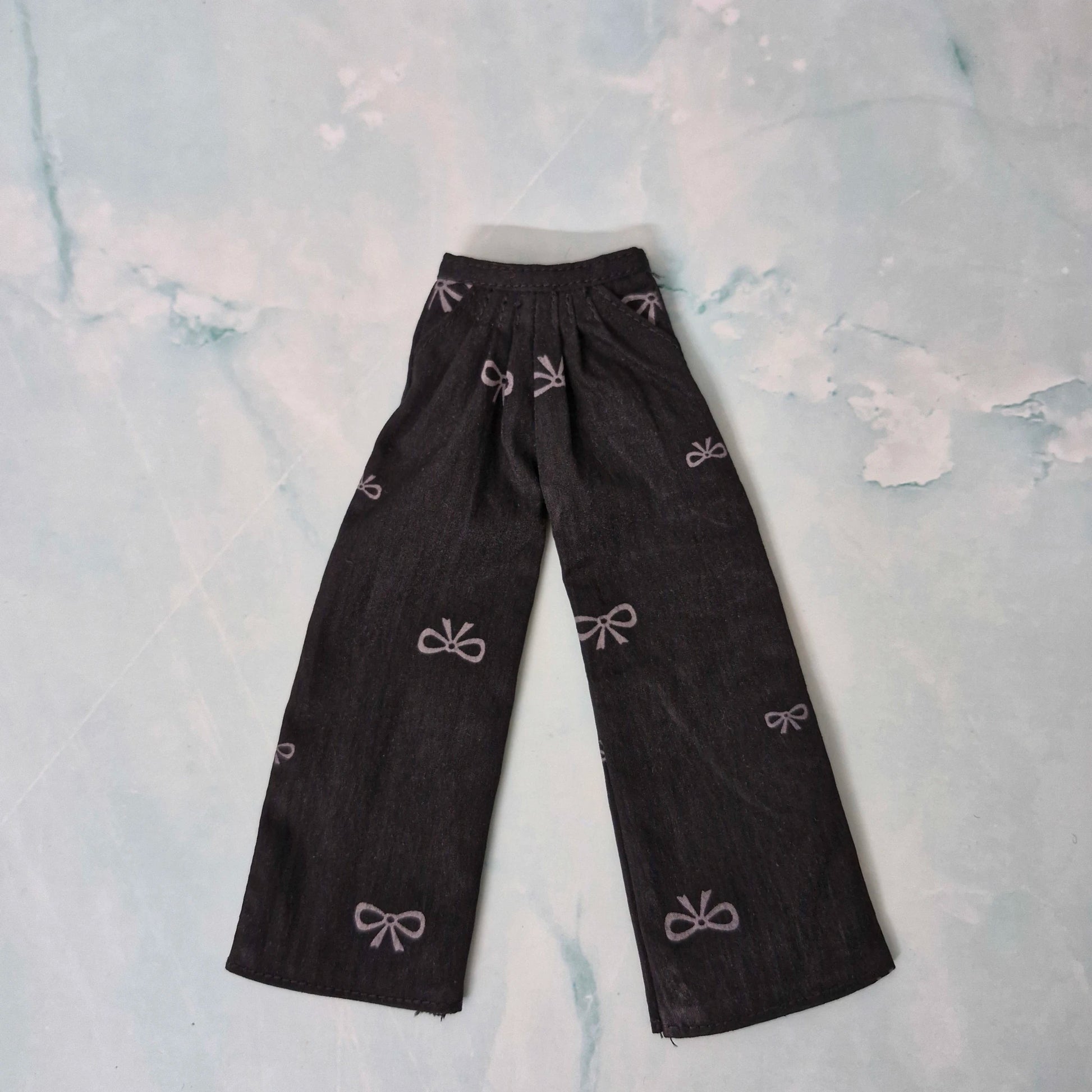 Black pants with bow patterns on a light blue floral background