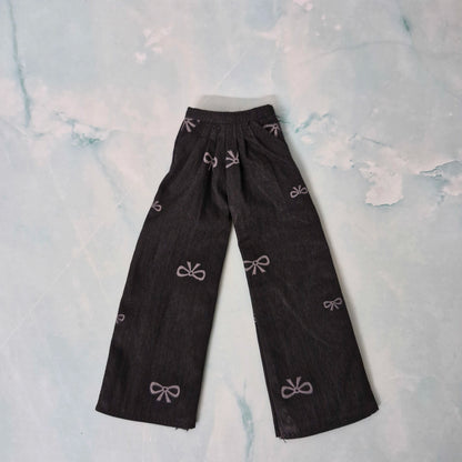 Black pants with bow patterns on a light blue floral background