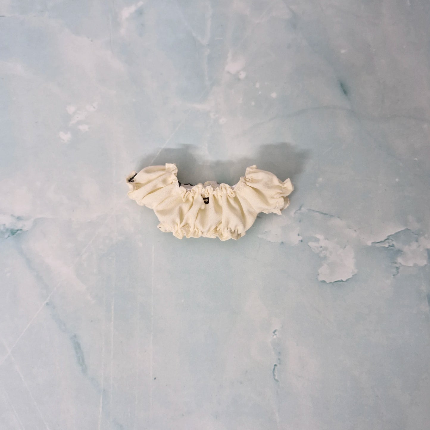 Cream-colored lace trim on a textured gray background