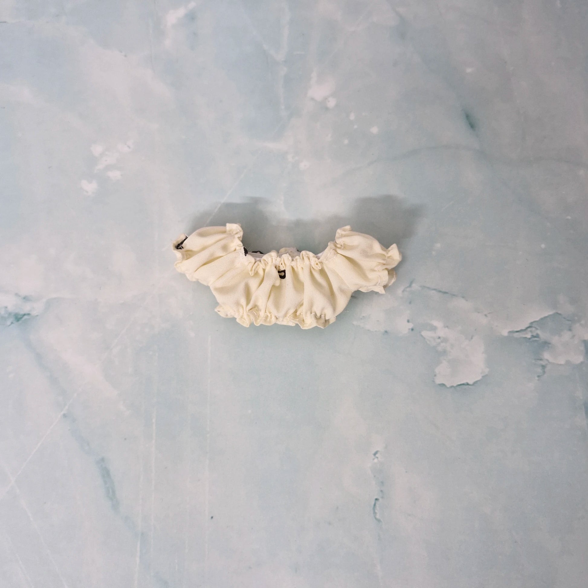 Cream-colored lace trim on a textured gray background