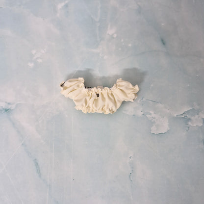 Cream-colored lace trim on a textured gray background