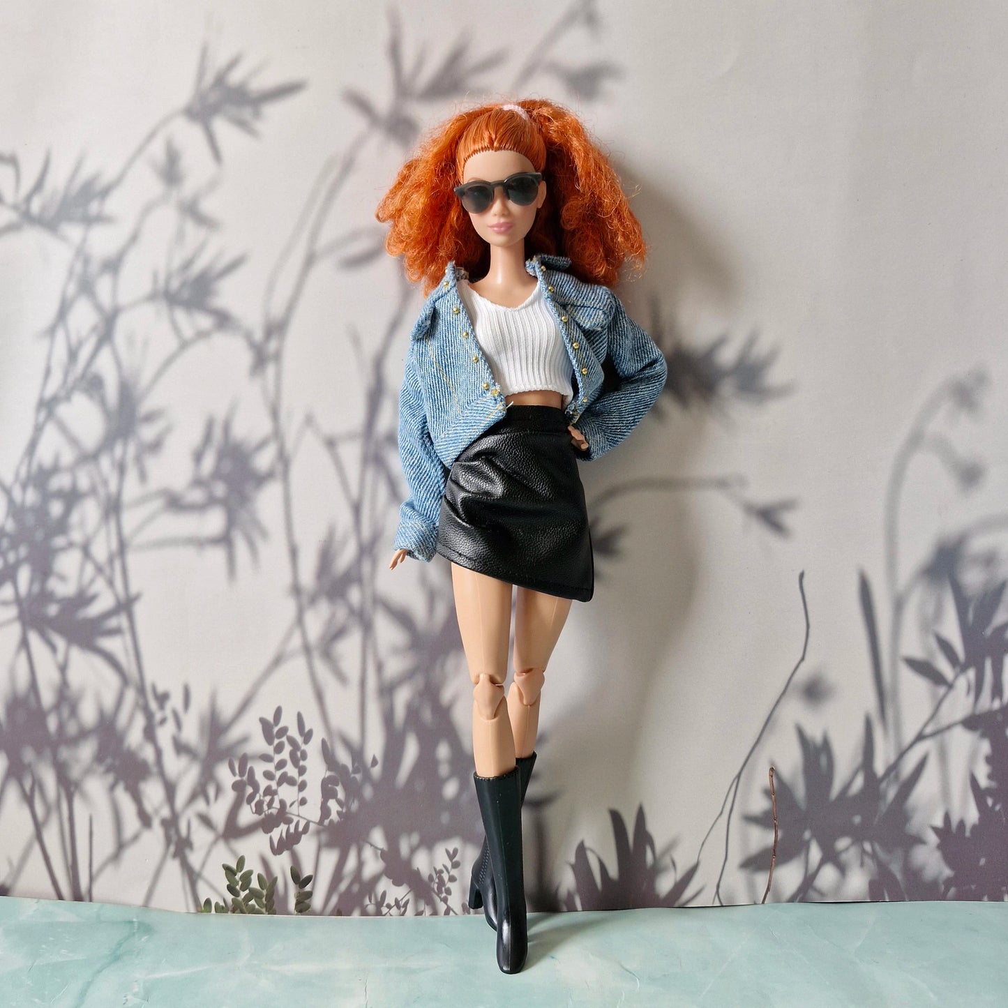 Barbie in denim jacket, white crop top, and black faux leather mini skirt
